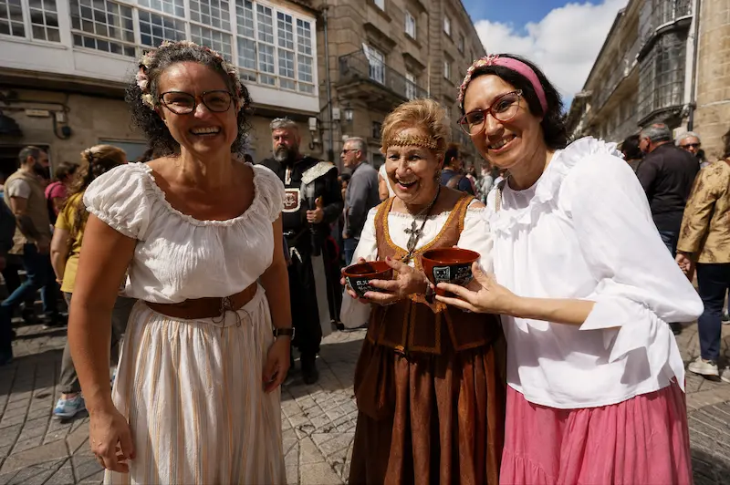 Tres participantes con vestimenta medieval y cuncas durante la Feira Franca de Pontevedra