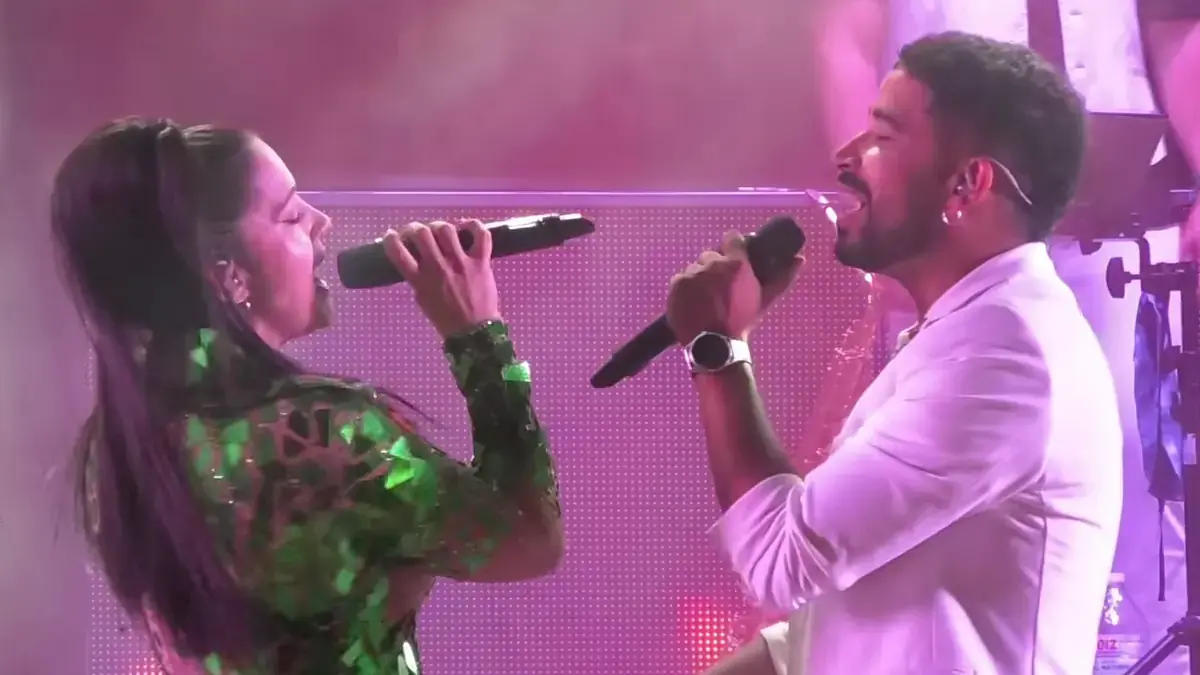 Dos cantantes de la Orquesta Gran Parada actuando juntos sobre el escenario