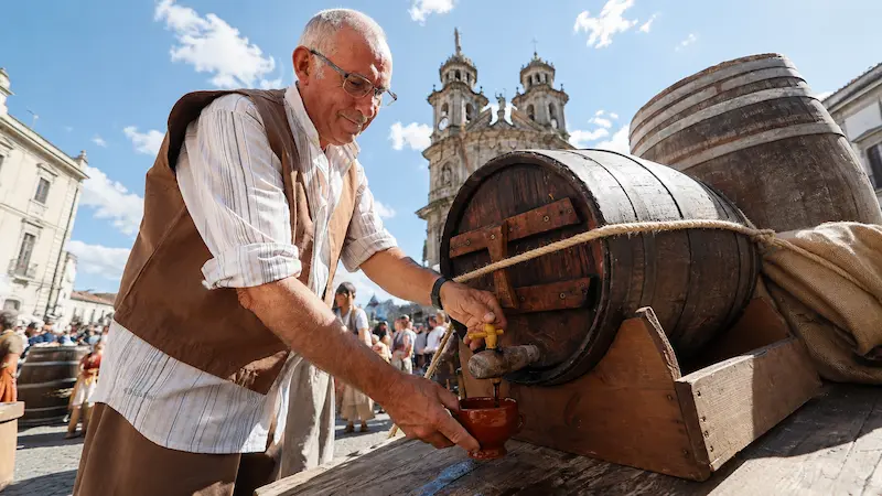 Hombre sirviendo vino de una barrica durante la Feira Franca de Pontevedra