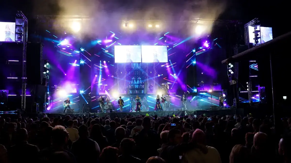 Concierto nocturno con escenario iluminado y numeroso público durante las Festas das Dores de Lalín.