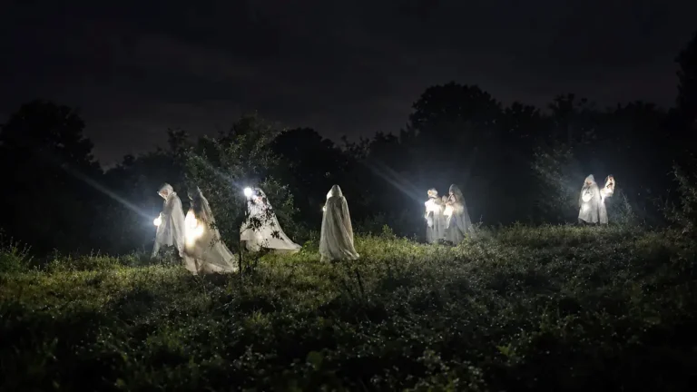 Figuras encapuchadas iluminadas durante la Procesión das Caveiras de Catoira.